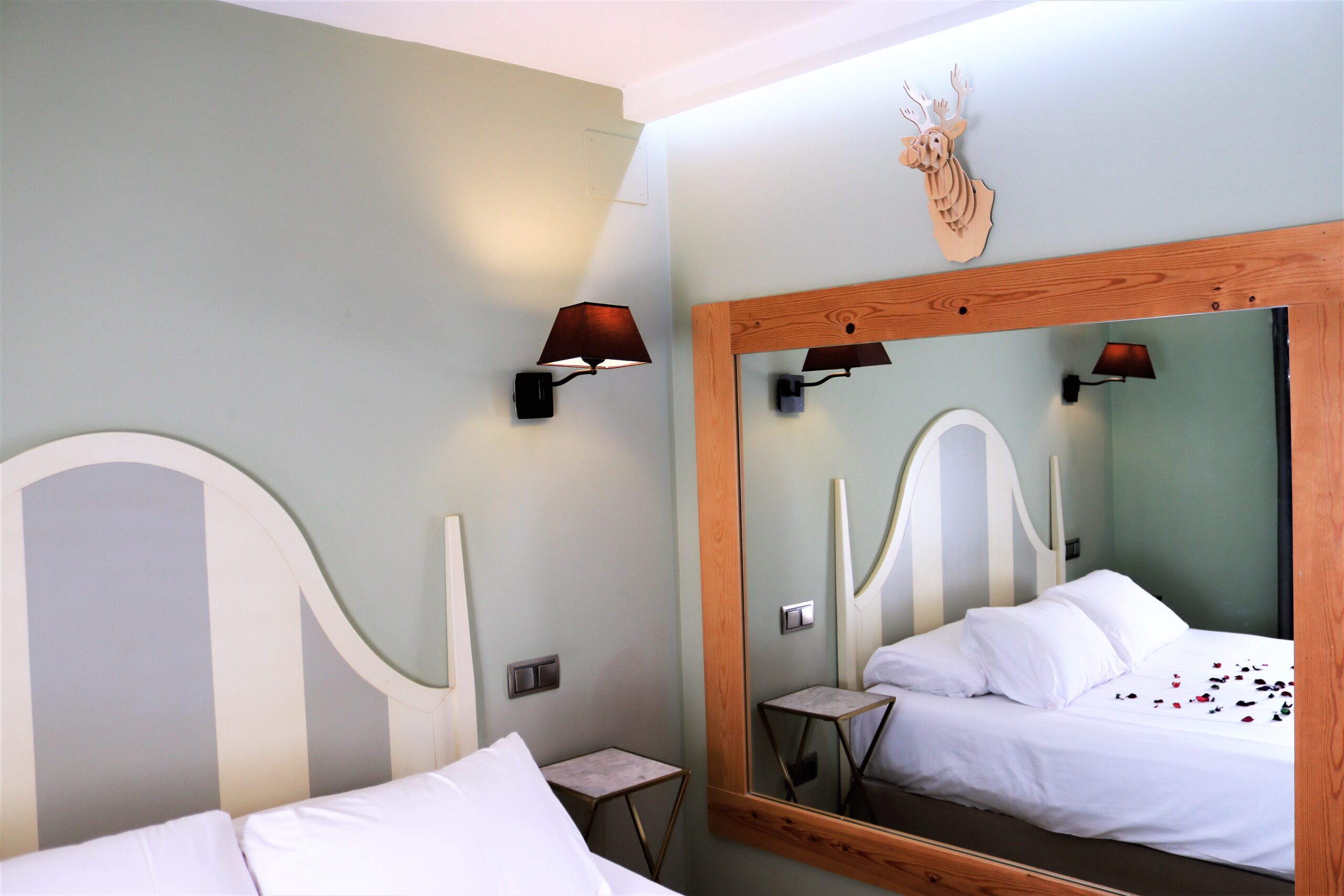 Espejo y cama en Suite El Bosque