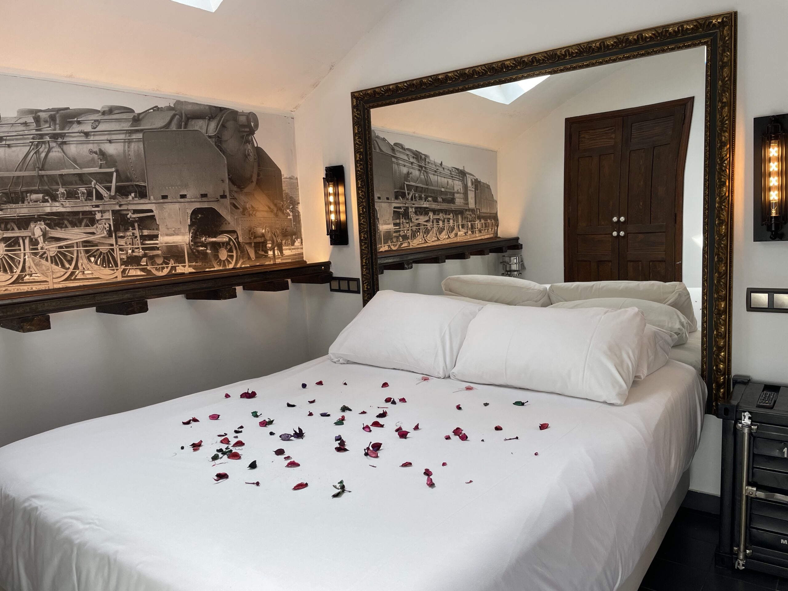 Cama y espejo en Suite El Apeadero
